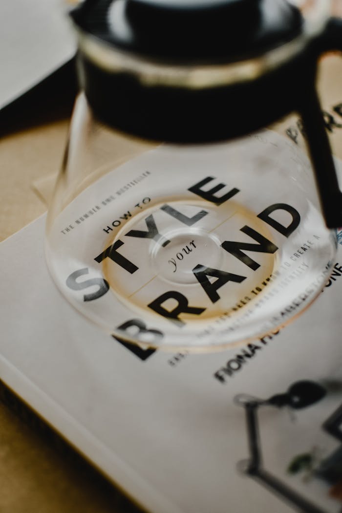 Mastering the First Impression: Your intriguing post title goes here A coffee pot rests atop a book titled 'How to Style Your Brand', capturing the essence of creative branding.